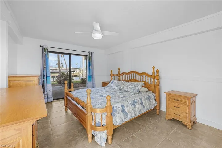 Bedroom featuring access to exterior, a ceiling fan, and tile patterned flooring