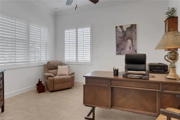 Tiled office space with crown molding and ceiling fan