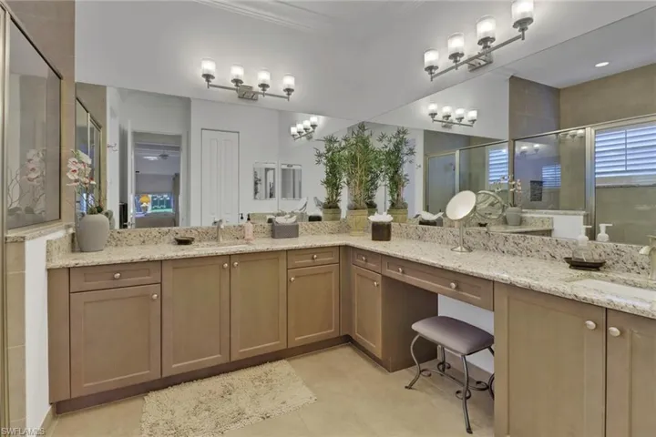 Bathroom featuring a shower with door, vanity, and tile patterned flooring