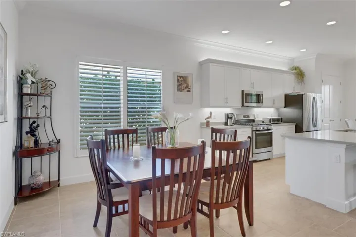 Dining room with crown molding, sink, and light tile patterned floors