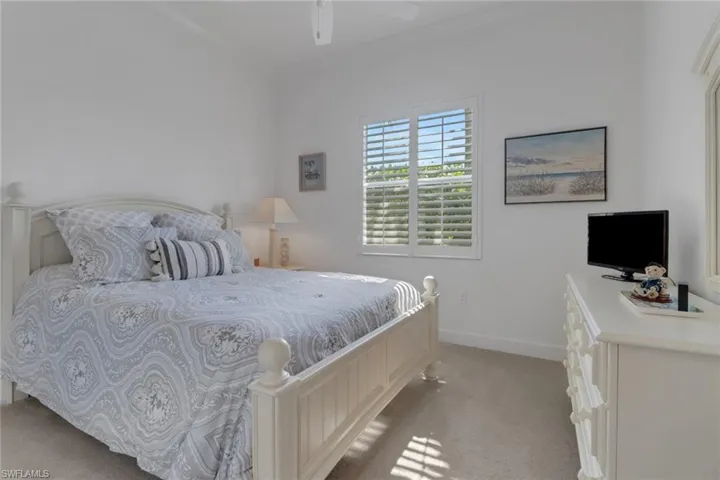 Bedroom featuring crown molding, ceiling fan, and light carpet