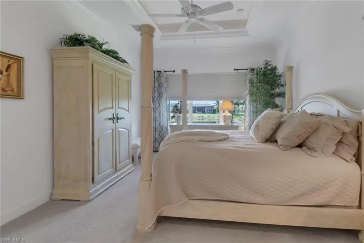 Bedroom featuring crown molding, light colored carpet, ceiling fan, and ornate columns