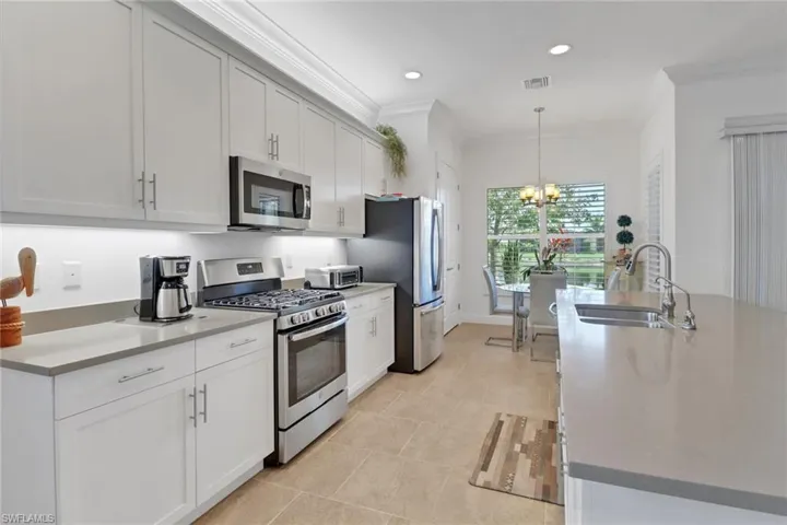 Kitchen featuring pendant lighting, white cabinetry, appliances with stainless steel finishes, and sink