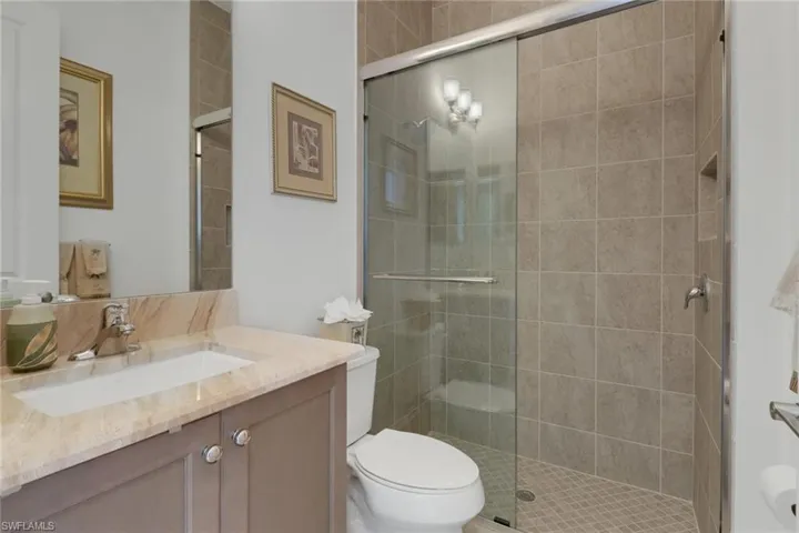 Bathroom featuring vanity, an enclosed shower, and toilet