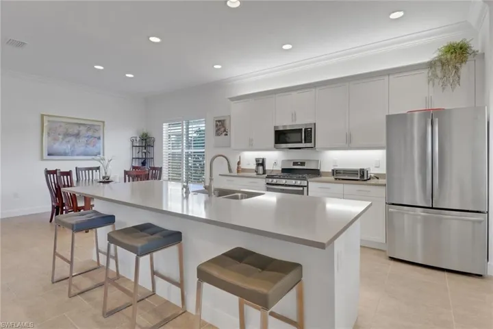 Kitchen with stainless steel appliances, a breakfast bar area, sink, and a center island with sink