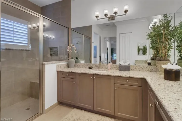 Bathroom with vanity, an enclosed shower, crown molding, and tile patterned flooring