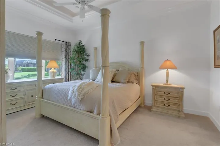 Bedroom with crown molding, light colored carpet, and ceiling fan