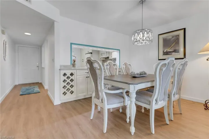 Dining area featuring a notable chandelier, baseboards, and light wood-style floors
