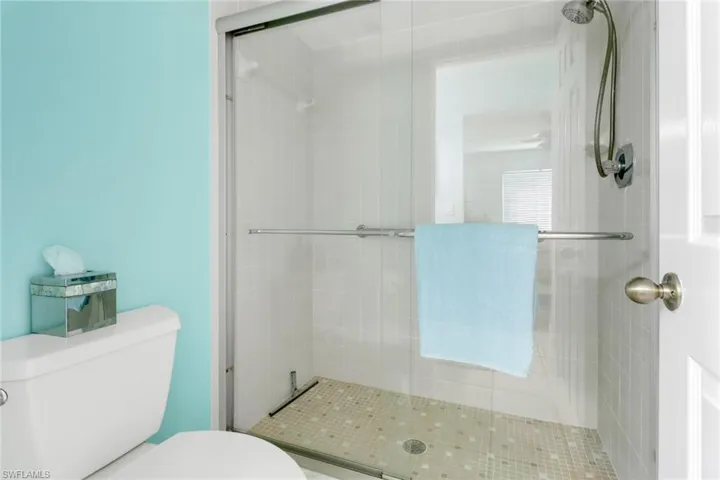 Full bathroom featuring toilet and a stall shower