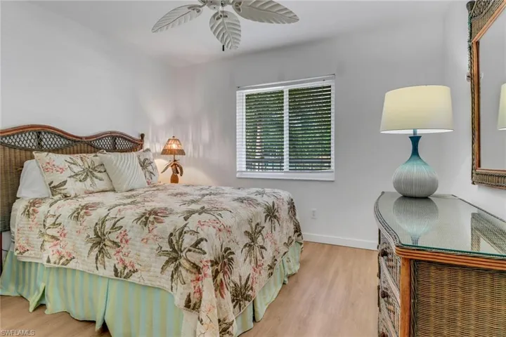 Bedroom featuring baseboards, wood finished floors, and ceiling fan