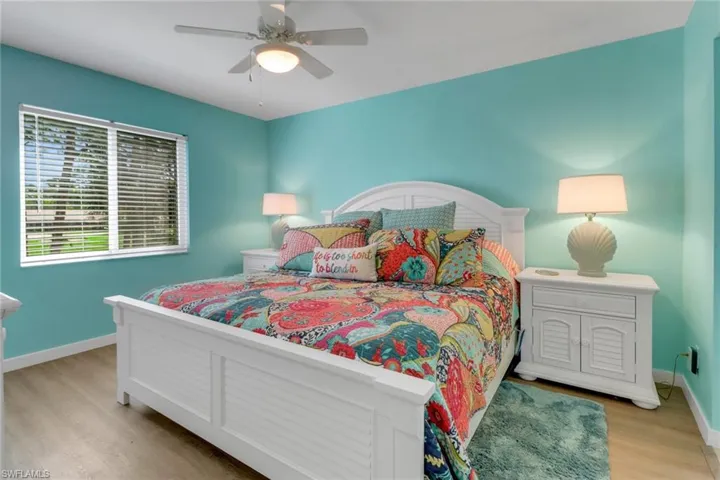 Bedroom with light wood finished floors, baseboards, and ceiling fan