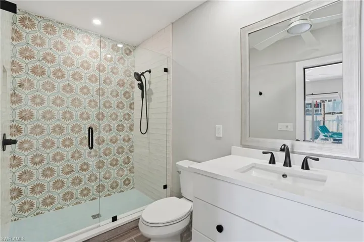 Full bathroom featuring a shower stall, vanity, recessed lighting, and ceiling fan - Virtually Edited Image