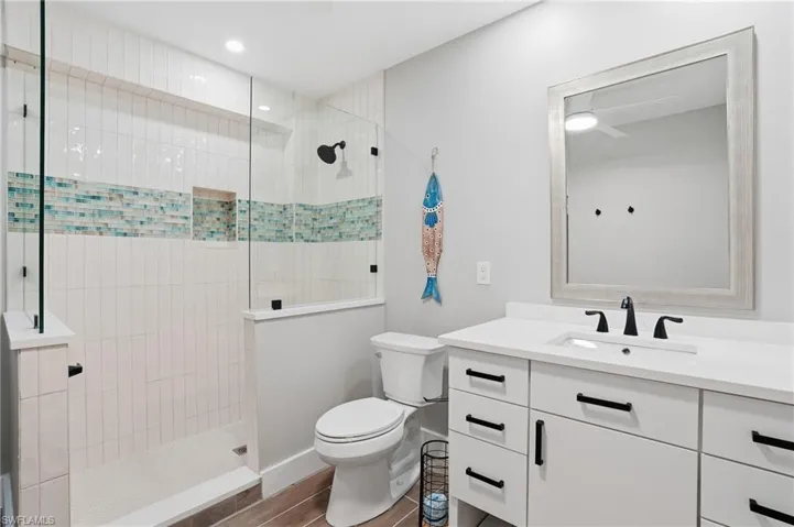 Full bathroom with vanity, walk in shower, and dark wood-style flooring - Virtually Edited Image