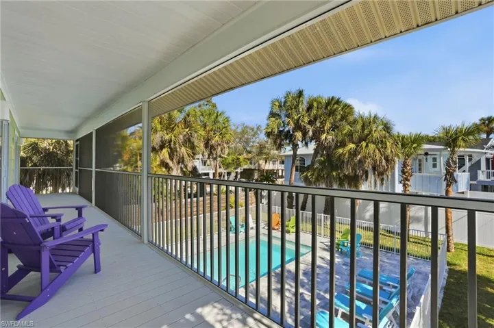 Balcony featuring view of pool and a sunroom - Virtually Edited Image