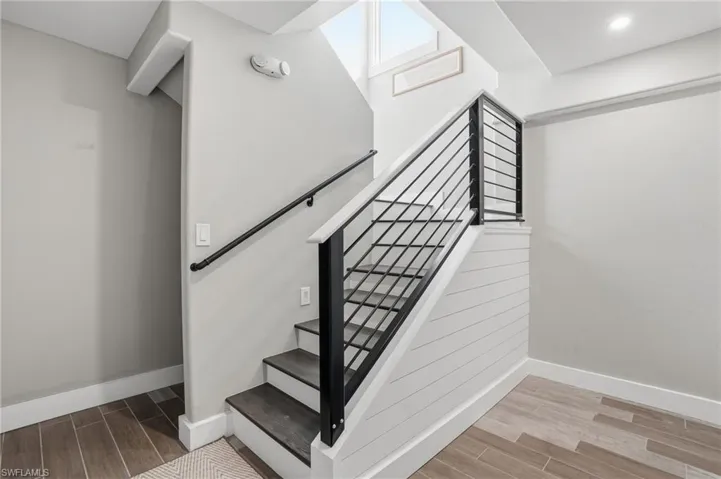 Stairway featuring wood tiled floors and baseboards - Virtually Edited Image