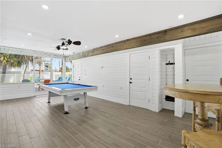 Playroom featuring a ceiling fan, wood walls, wood finish floors, billiards table, and recessed lighting - Virtually Edited Image