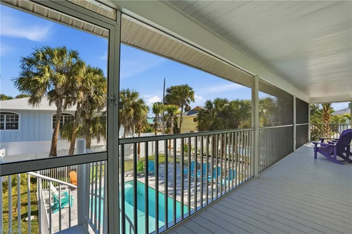 Balcony featuring view of pool and a sunroom - Virtually Edited Image
