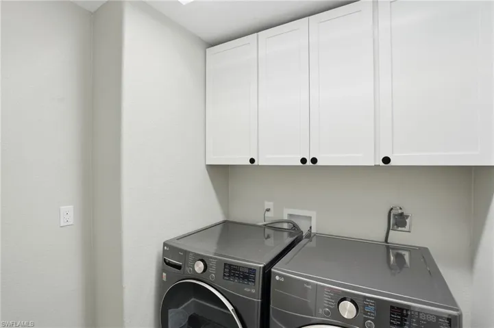 Laundry area featuring cabinet space and washer and dryer - Virtually Edited Image