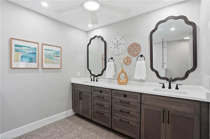 Bathroom featuring double vanity, ceiling fan, and recessed lighting - Virtually Edited Image