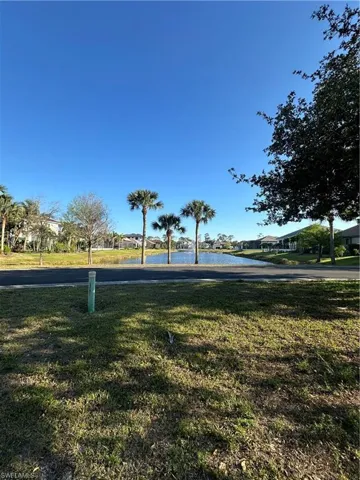 View of property's community with a water view and a lawn