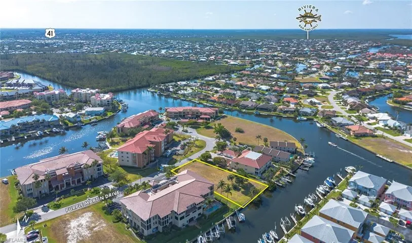Aerial view of residential area with a nearby body of water and property parcel outlined