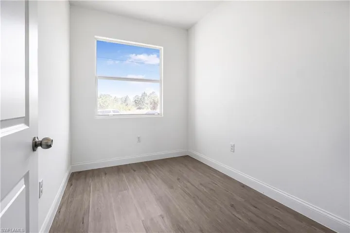 Unfurnished room featuring baseboards and wood finished floors