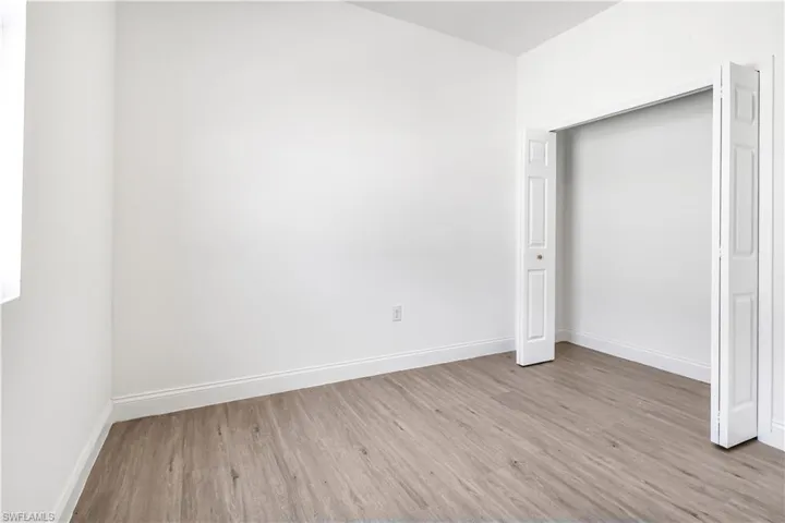 Unfurnished bedroom featuring wood finished floors and baseboards