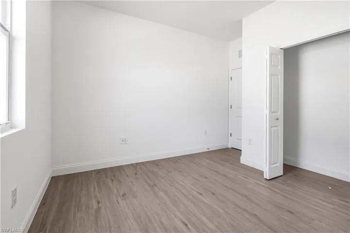 Unfurnished bedroom featuring wood finished floors and baseboards