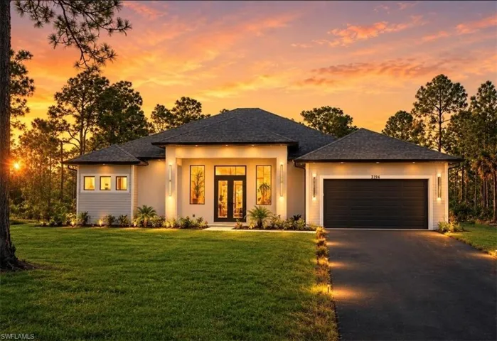 Contemporary residence featuring a dark asphalt shingle roof and a light stucco exterior
