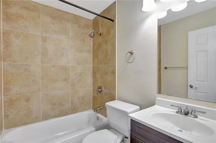 Guest Bathroom with vanity, a textured wall, and bathtub / shower combination