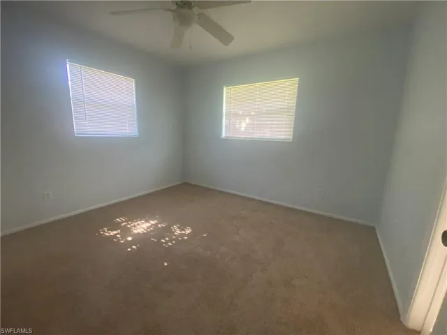 Carpeted empty room featuring ceiling fan