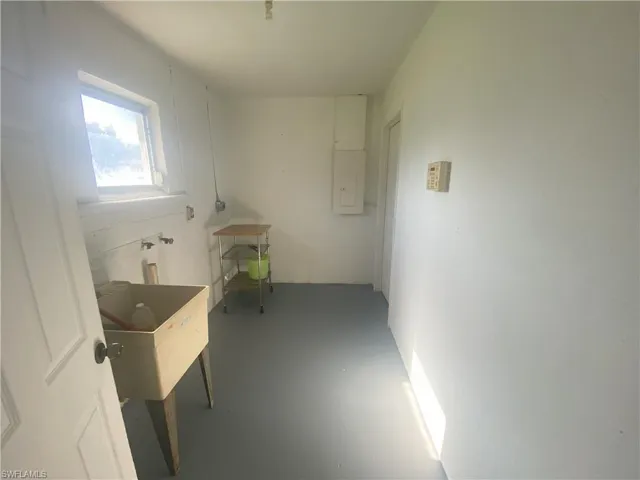 Additional living space featuring electric panel and concrete floors