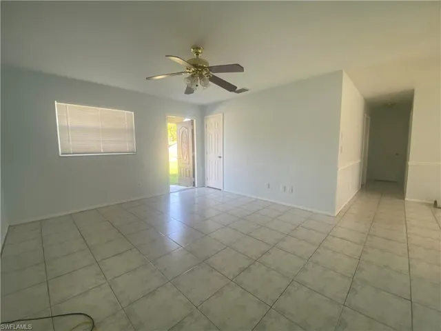 Tiled spare room featuring ceiling fan