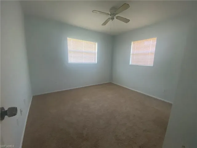 Unfurnished room featuring carpet flooring and ceiling fan