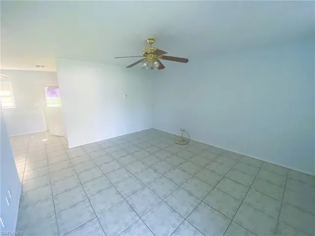 Unfurnished room with ceiling fan and light tile patterned floors