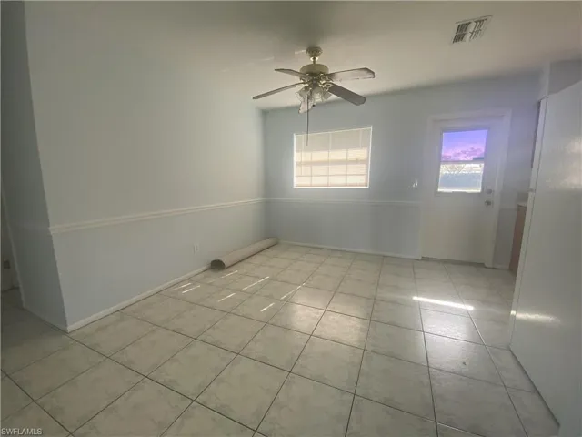 Tiled spare room with ceiling fan