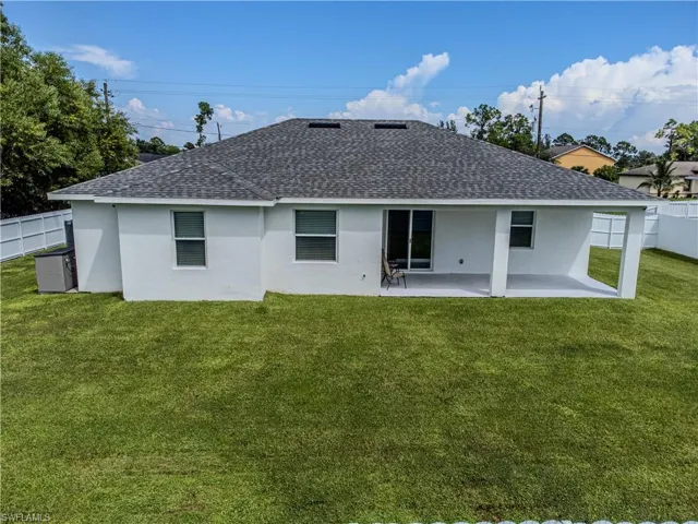 Back of house featuring a lawn and a patio