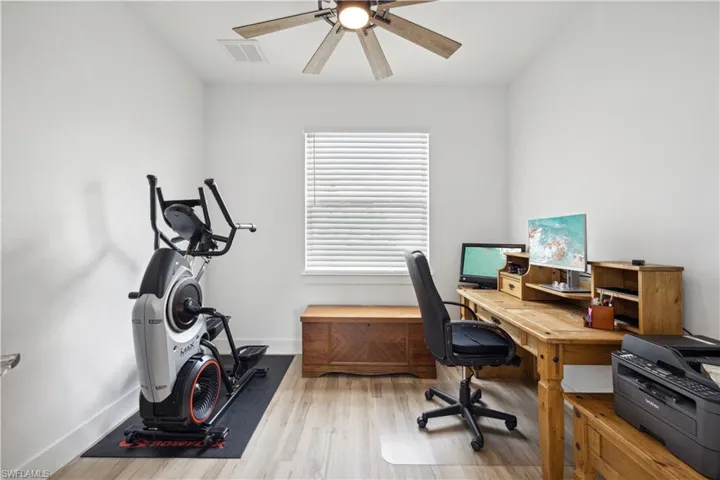 Home office featuring ceiling fan and light hardwood / wood-style floors