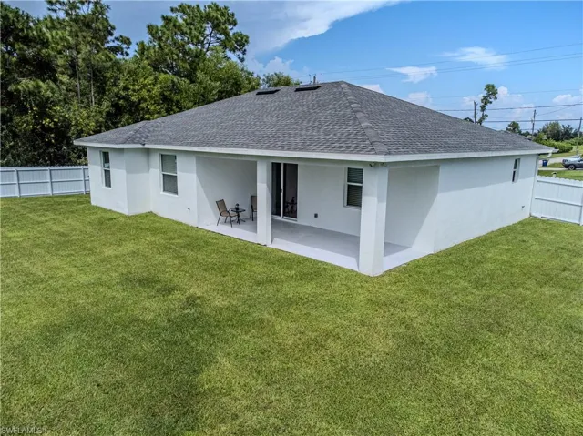 Rear view of house featuring a yard and a patio