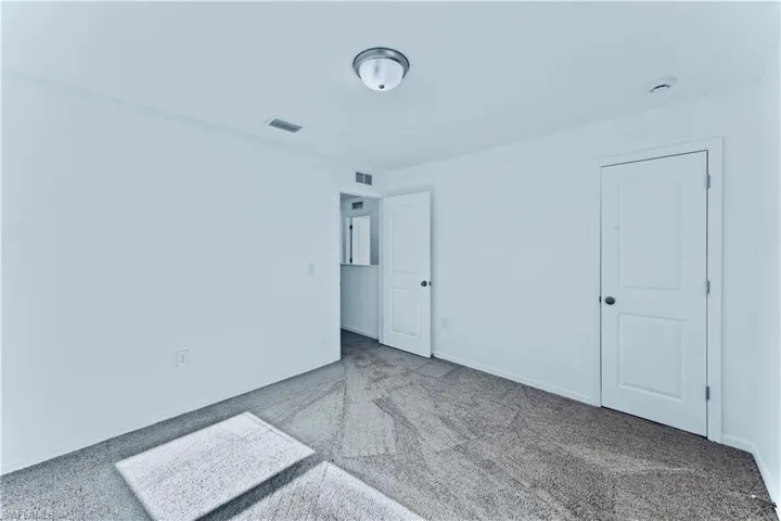 Unfurnished bedroom with visible vents, baseboards, and carpet floors