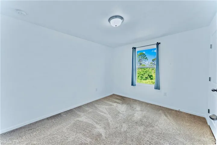 Carpeted spare room with baseboards