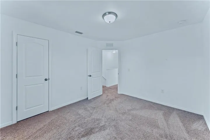 Unfurnished bedroom featuring visible vents, baseboards, and carpet floors