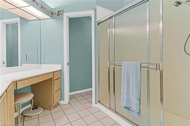 Bathroom with a shower with door, tile flooring, and vanity