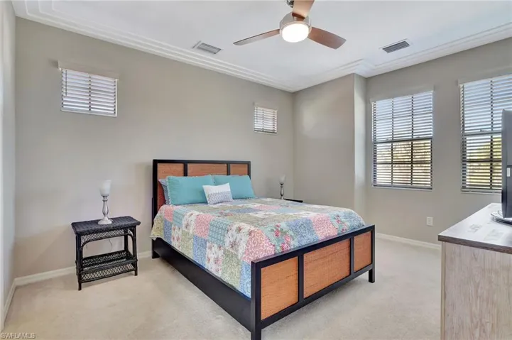 Primary Bedroom with ceiling fan and light carpet