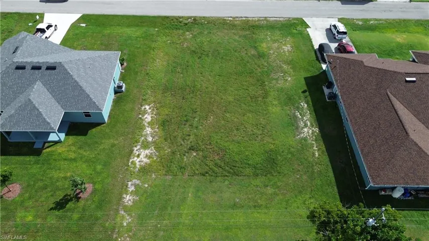 Expansive undeveloped lot with street frontage, surrounded by existing residential properties