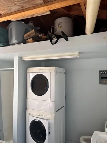 Laundry area with stacked washer and clothes dryer