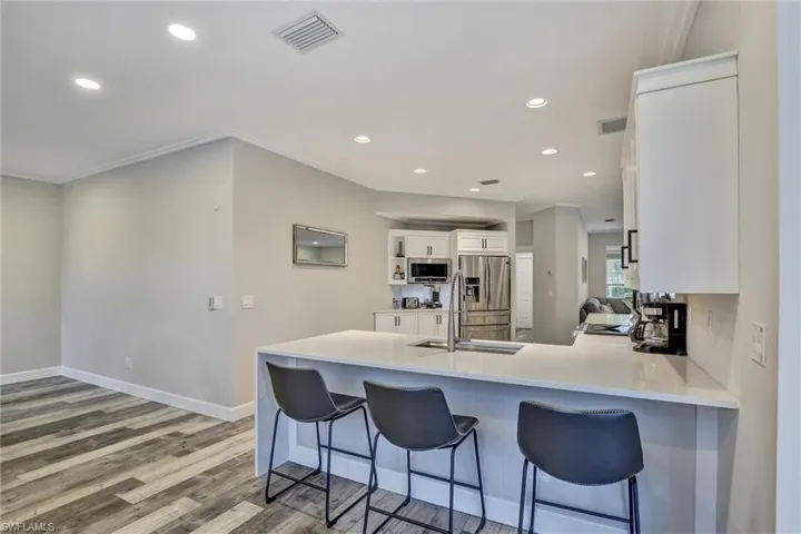 Kitchen island featuring a white countertop with integrated sink and chrome faucet