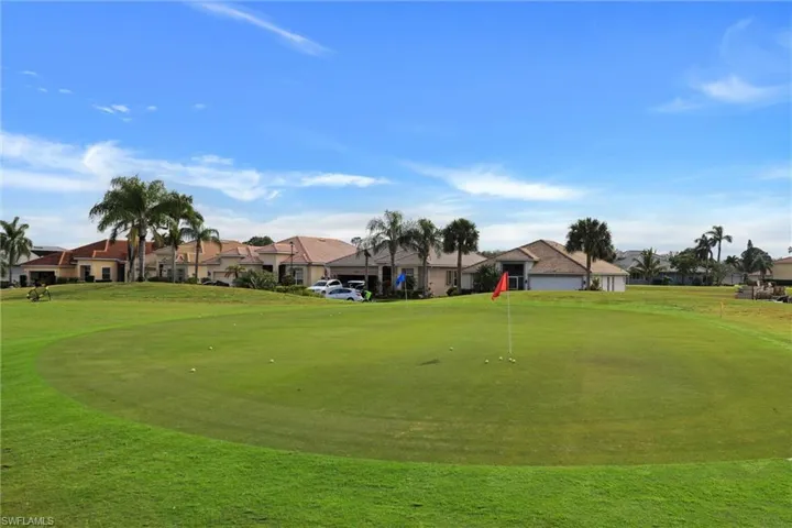 Golf course putting green featuring a flagstick and golf balls