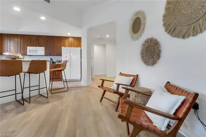 Kitchen with crown molding, white appliances, and light hardwood / wood-style flooring