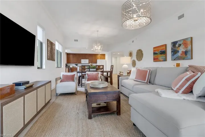 Living room featuring crown molding and an inviting chandelier